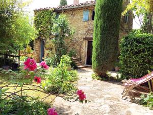 ein Garten mit rosa Blumen und einem Haus in der Unterkunft B&B Petite Maison Le Jardin in Vaison-la-Romaine