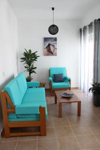 a living room with two blue chairs and a table at Casa Da Baía in Lagos