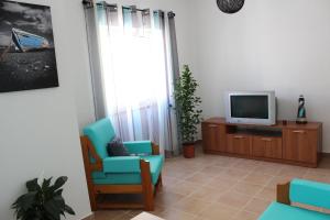 ラゴスにあるCasa Da Baíaのリビングルーム(テレビ、青い椅子付)