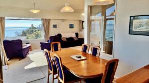 uma sala de jantar com uma mesa e uma sala de estar em Kimberley Three - Nelson Waterfront Penthouse em Nelson