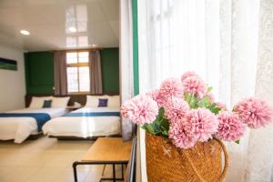 金寧鄉的住宿－阿鑫民宿，一间有花瓶的房间,里面装有粉红色的花
