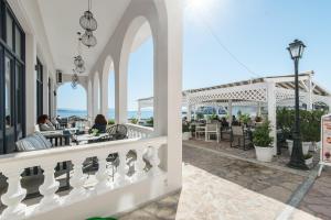 a view of a patio with people sitting at tables at Klimis Hotel in Spetses +15 photos