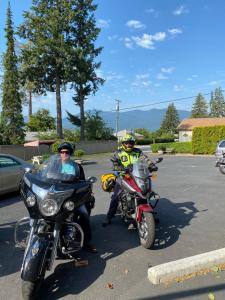 two people on motorcycles parked in a parking lot at City Centre Motel in Creston