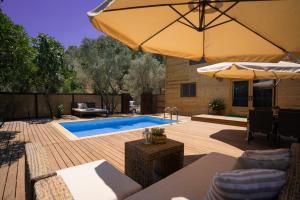 a patio with a pool and an umbrella at Dedemuem Adrasan in Kumluca