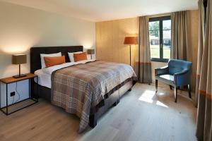 a hotel room with a bed and a blue chair at Eiger View Alpine Lodge in Grindelwald