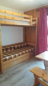 Cette chambre comprend 2 lits superposés et une table. dans l'établissement Studio Champerouze 127, à La Toussuire
