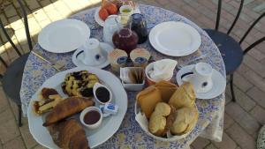 Valdorcia Belvedere b&b في بينزا: طاولة زرقاء وبيضاء عليها صحون طعام