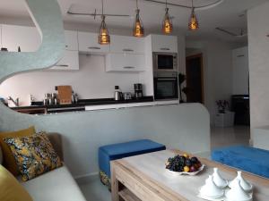 a living room with a table with a bowl of fruit on it at perle rare plage des Nations in Sidi Bouqnadel