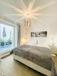 ein Schlafzimmer mit einem großen Bett und einem Kronleuchter in der Unterkunft 3-Raum Apartment Quartier57 Hamburg-Eppendorf in Hamburg