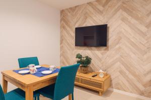 a dining room table with chairs and a television on a wall at Hotel Santa Barbara Miyakojima Resort in Miyako-jima