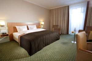 a hotel room with a large bed and a chair at Lind Hotel in Rietberg