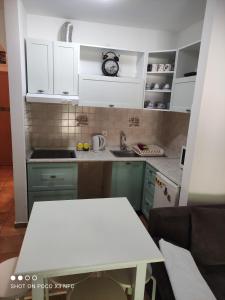 a kitchen with white cabinets and a white table at Apartment Mira in Petrovac na Moru