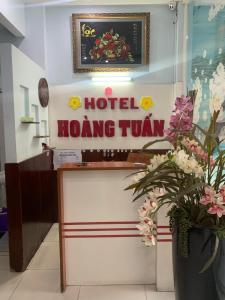 a hotel hong tun sign in a room with flowers at Hoang Tuan Hotel in Ho Chi Minh City