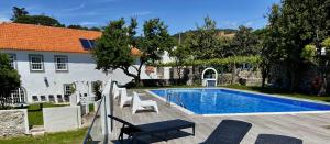 a swimming pool in front of a house at Solar Laginha - apartamentos e quartos in Afife