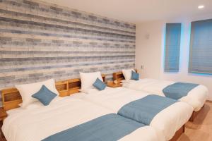 a row of three beds in a room at Hotel Santa Barbara Miyakojima Resort in Miyako-jima