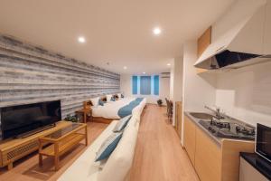 a large living room with two beds and a flat screen tv at Hotel Santa Barbara Miyakojima Resort in Miyako-jima