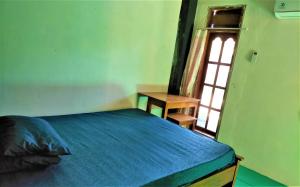 バニュワンギにあるCheap Inn Banyuwangiの青いベッドと窓のある寝室