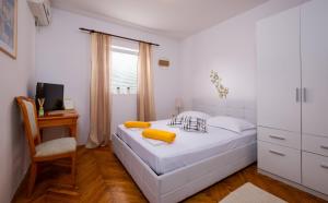 um quarto branco com uma cama e uma secretária em Apartments Botica em Mlini