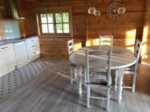eine Küche mit einem Tisch und Stühlen in einer Hütte in der Unterkunft Le Chalet Caux-Marin in Tourville-la-Chapelle