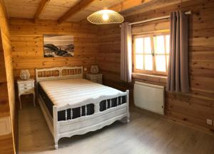 ein Schlafzimmer mit einem Bett in einem Blockhaus in der Unterkunft Le Chalet Caux-Marin in Tourville-la-Chapelle