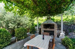 a table and chairs and a stone fireplace in a yard at Holiday Home Blue Vineyard in Potomje