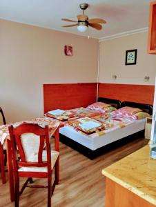 sypialnia z łóżkiem i stołem z krzesłem w obiekcie Liza Apartman w mieście Gyula