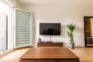 a living room with a large window and a tv at Superbe Studio à 2 Stations de Paris Centre 15min à pied du Stade de France in Saint-Denis