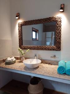 a bathroom with a sink and a mirror on a counter at Maison Ed-Elle in La Digue