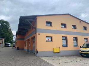 a building with a car parked in front of it at Budziechów Noclegi in Lubsko