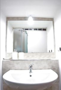 uma casa de banho com um lavatório branco e um espelho. em NOVA DOMUS em Bitonto
