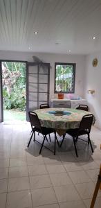 Pokój ze stołem, krzesłami i łóżkiem w obiekcie Villa Azalées w mieście Salazie