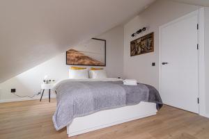 biała sypialnia z dużym łóżkiem i schodami w obiekcie Zydu str two bedrooms Apartment by URBAN RENT w Wilnie