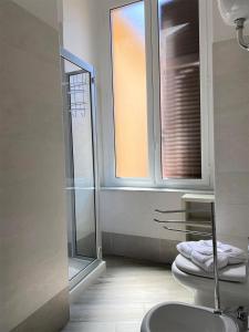 a bathroom with a shower and a toilet and a window at I Decumani in Naples