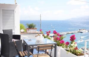 une table et des chaises sur un balcon avec vue sur l'océan dans l'établissement Casa Tarantino Charming apartments, à Capri