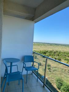 a balcony with tables and chairs and a view of the desert at Gabriela Blaxy Apartamente in Olimp