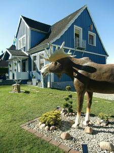 a statue of a moose in front of a house at FERIENWOHNUNG HEIDESCHWEDIN ll in Eschede
