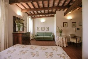 um quarto com uma cama, um sofá e uma mesa em Agriturismo Bricco San Giovanni em Isola d'Asti