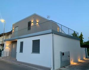 a white building with a balcony on top at Villa Luminosa in Torre del Lago Puccini