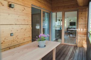 Habitación de madera con una mesa con flores. en Apart Rauchkofel en Lienz