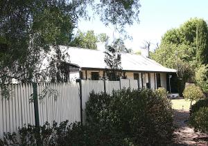 a white fence in front of a house at Miss Mabel Cottage in Burra
