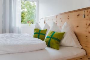 een slaapkamer met een wit bed met 4 kussens bij Apart Rauchkofel in Lienz