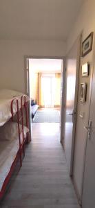 pasillo que conduce a un dormitorio con cama y puerta en Les Marines d'Agay Studio climatisé en Saint-Raphaël