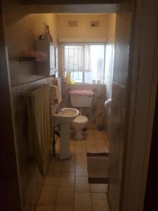 a bathroom with a toilet and a sink and a window at 54 Martjie laan in Brits
