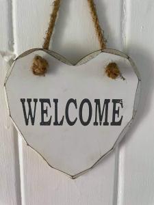 a sign with the word welcome hanging on a door at Dream Cottage in Ballintober