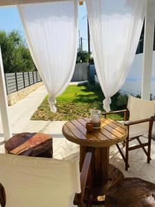 a patio with a table and chairs on a patio at Joyas cosy apartment in Tragaki