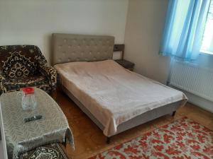 a bedroom with a bed and a chair and a table at Ani Guest House in Tsaghkadzor