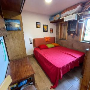 1 dormitorio con 1 cama roja en una habitación en Appartamento L'Araba Fenice, en Pizzoferrato