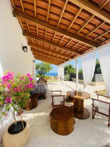 un patio con mesas de madera, sillas y flores en Joyas cosy apartment, en Tragaki