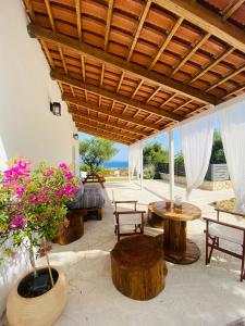 a patio with wooden tables and chairs and flowers at Joyas cosy apartment in Tragaki