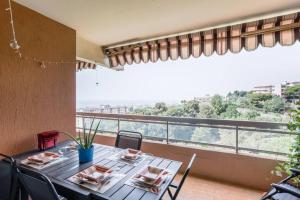 a dining room with a table and chairs and a balcony at Sea view apartment in residence with swimming pool! in Nice